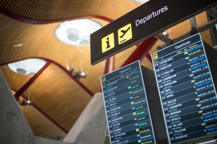 Airport departure board showing flight information under a 'Departures' sign.