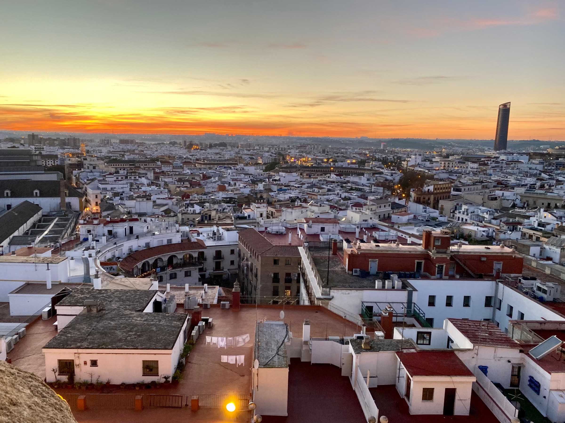 Urban skyline at sunset with a tall building in the background.